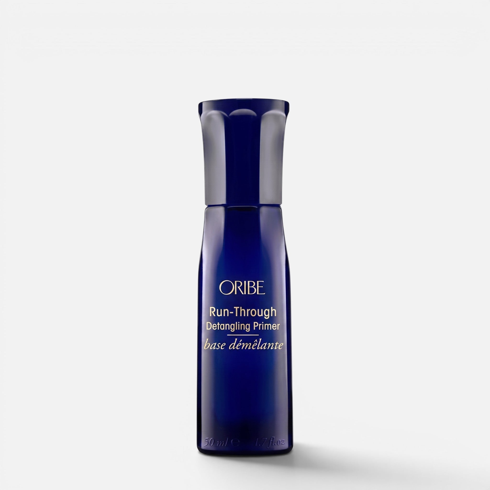 Shop Rescue Spa Oribe Run-Through Detangling Primer in a 1.7 oz dark blue travel-size bottle.