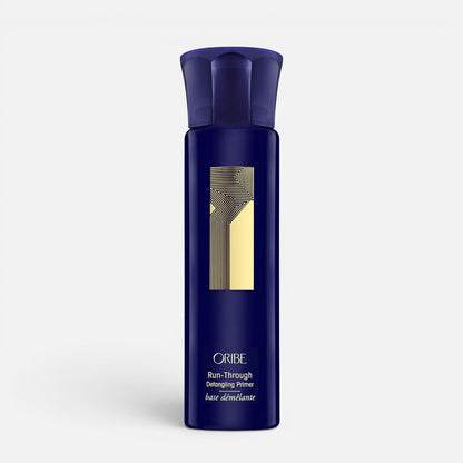 Shop Rescue Spa Oribe Run-Through Detangling Primer in a dark blue spray bottle for heat protection and detangling.
