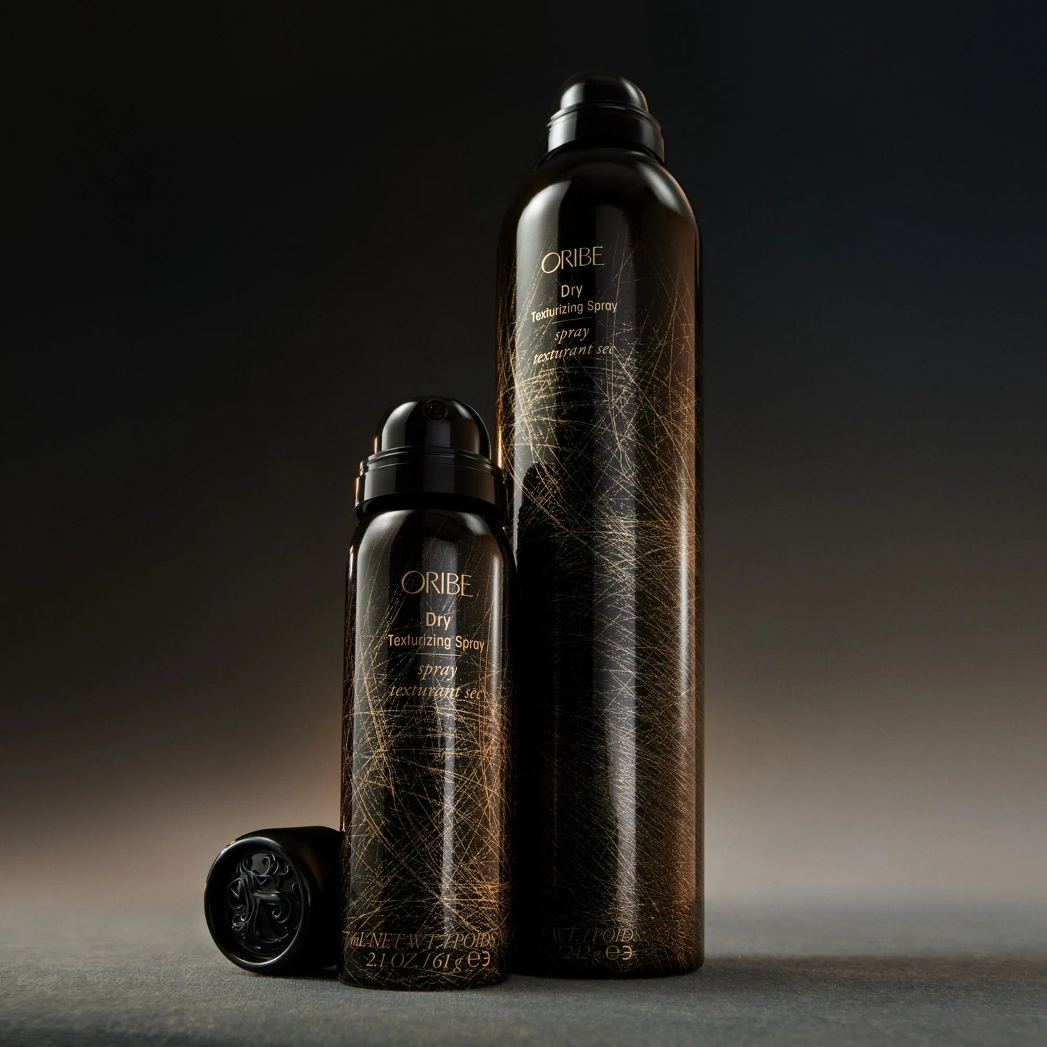 Shop Rescue Spa Oribe Dry Texturizing Spray bottles in travel and full sizes with black and gold packaging.