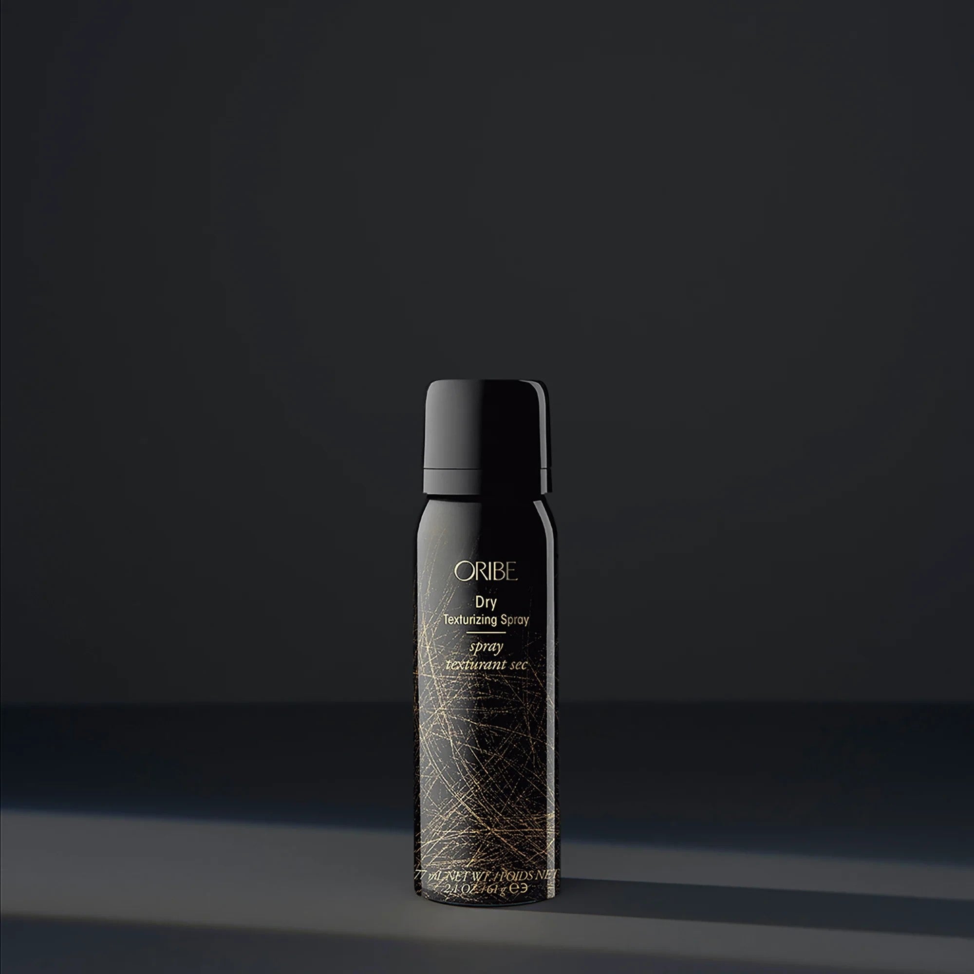 Shop Rescue Spa Oribe Dry Texturizing Spray in a black bottle with gold abstract line design for hair volume
