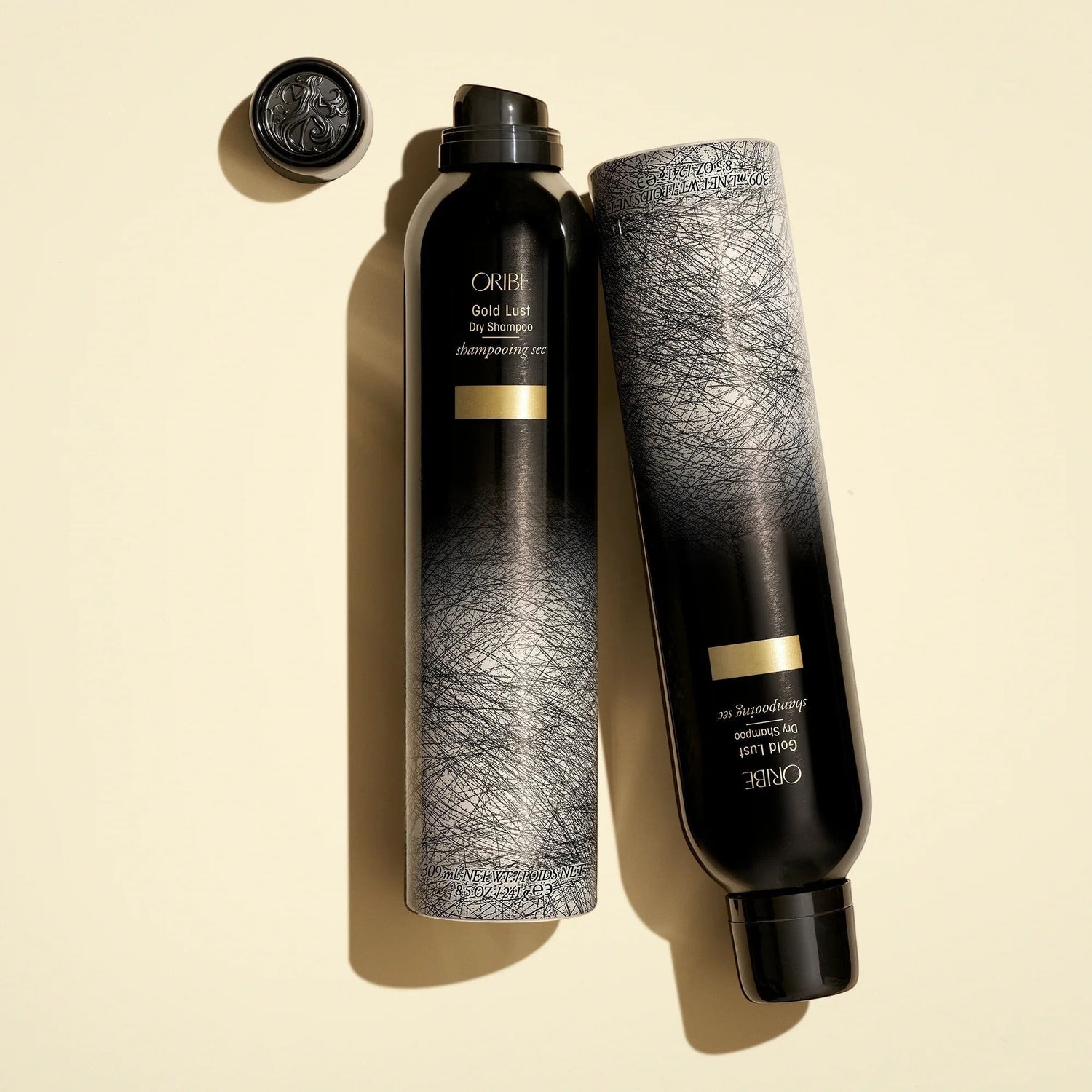 Shop Rescue Spa Oribe Gold Lust Dry Shampoo bottles in black and grey packaging with gold accents on a cream background
