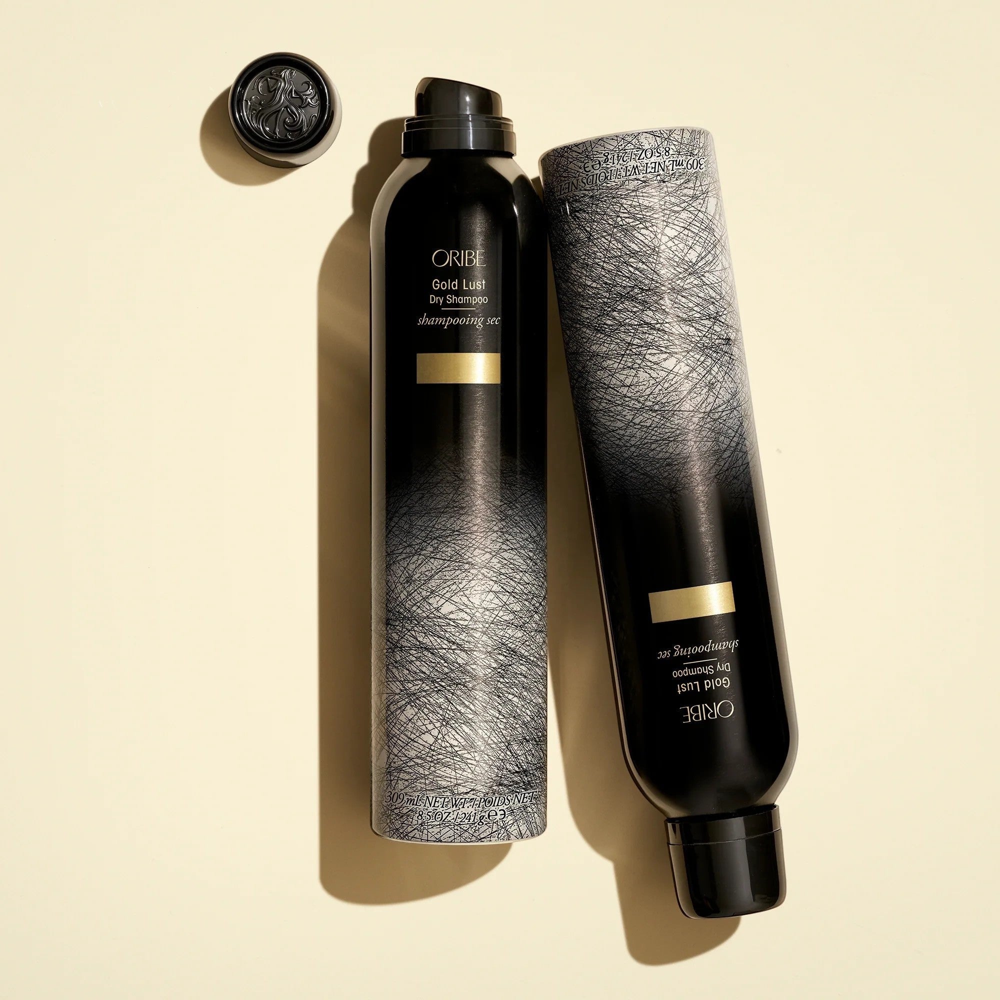Shop Rescue Spa Oribe Gold Lust Dry Shampoo bottles in black and grey packaging with gold accents on a cream background