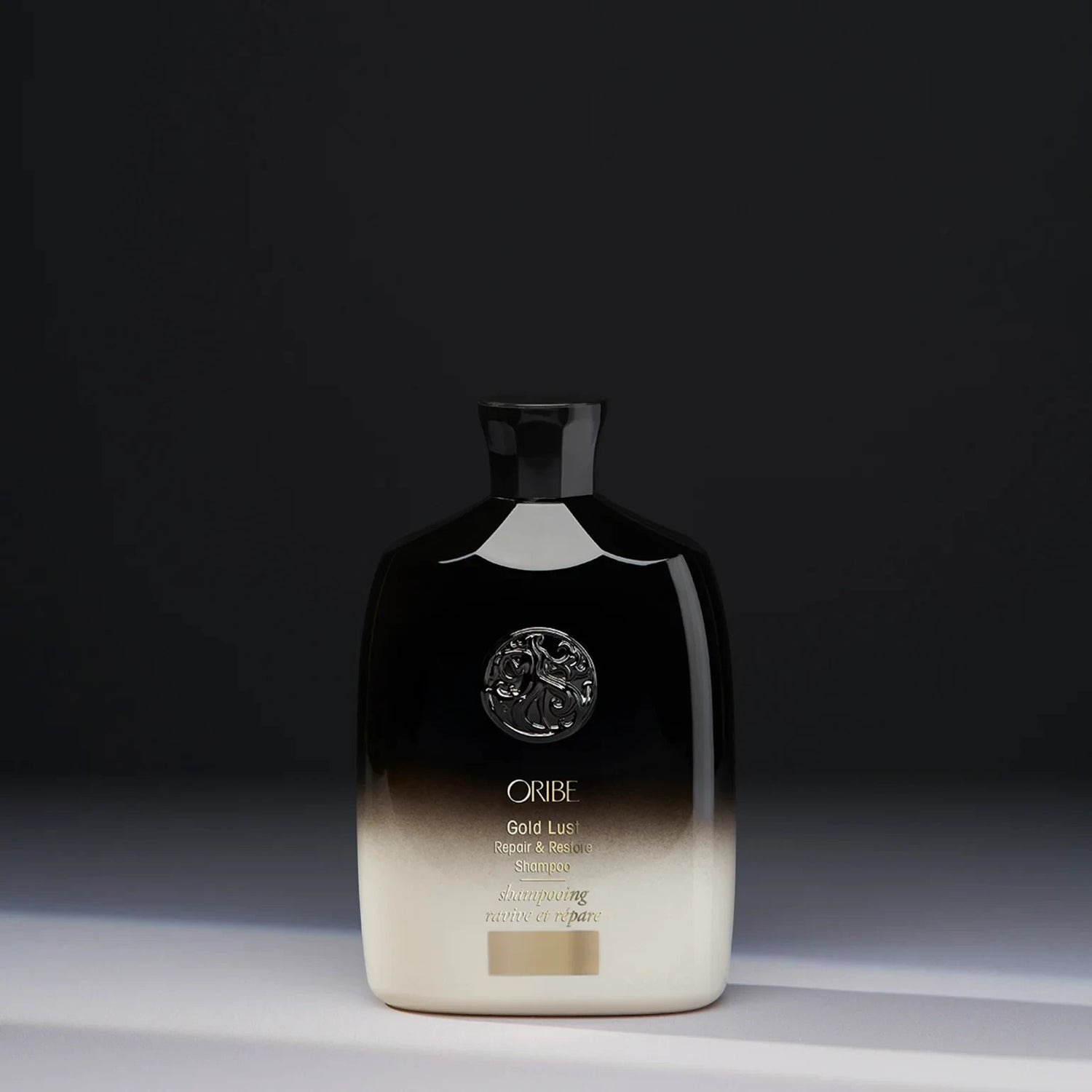 Shop Rescue Spa Oribe Gold Lust Repair and Restore Shampoo in a black and cream bottle against a dark background.