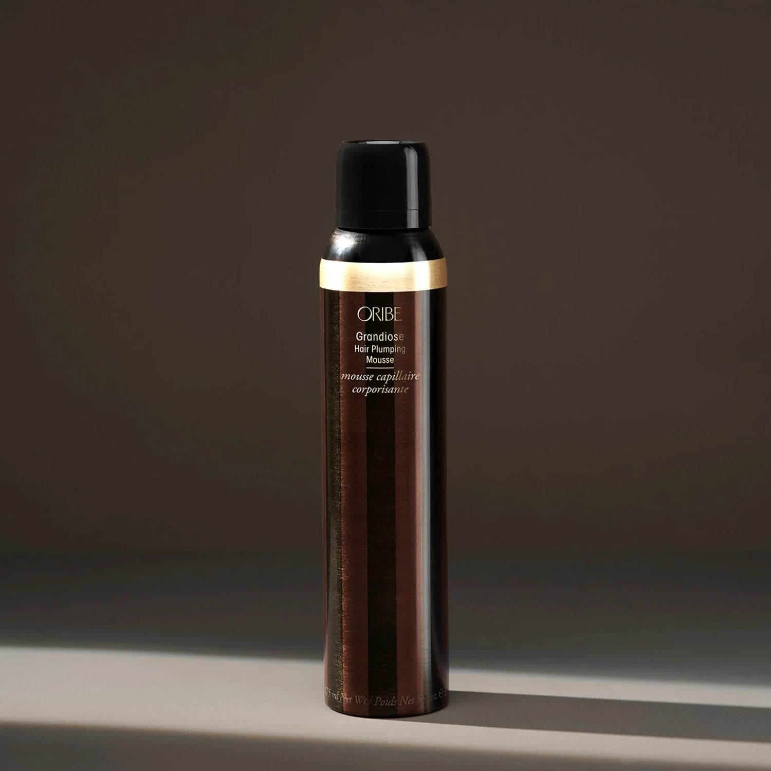Shop Rescue Spa Oribe Grandiose Hair Plumping Mousse in a sleek brown and gold canister for voluminous hair styling.