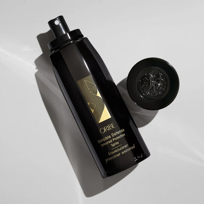 Shop Rescue Spa Oribe Invisible Defense Universal Protection Spray in a black bottle with a gold logo on white surface