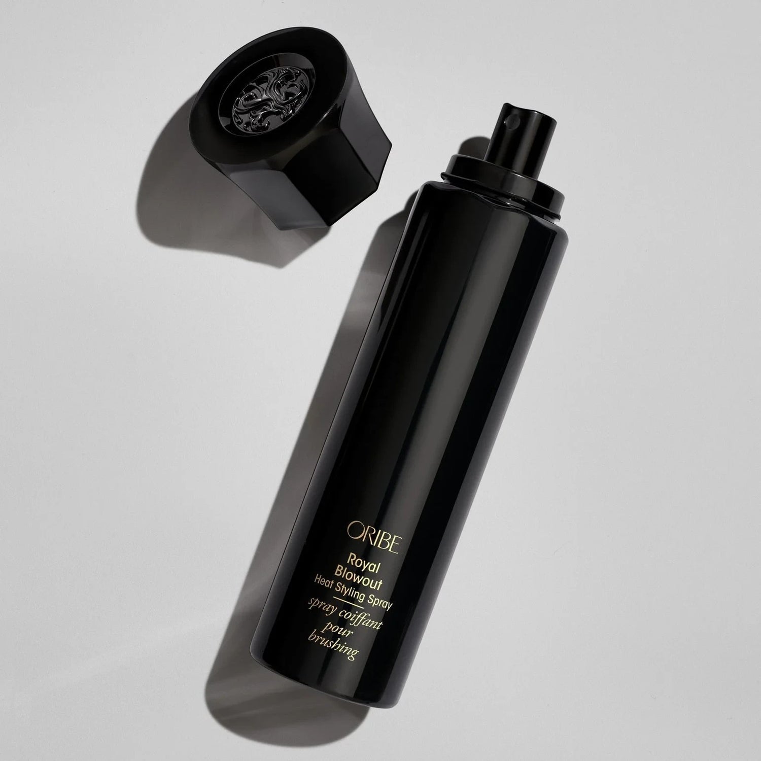 Shop Rescue Spa Oribe Royal Blowout Heat Styling Spray in a sleek black bottle with the cap removed.