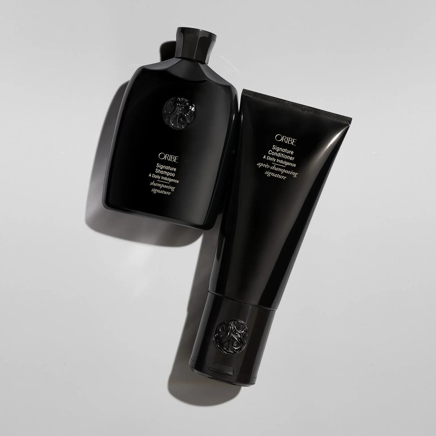Shop Rescue Spa Oribe Signature Shampoo and Conditioner set in black bottles for daily hair nourishment.