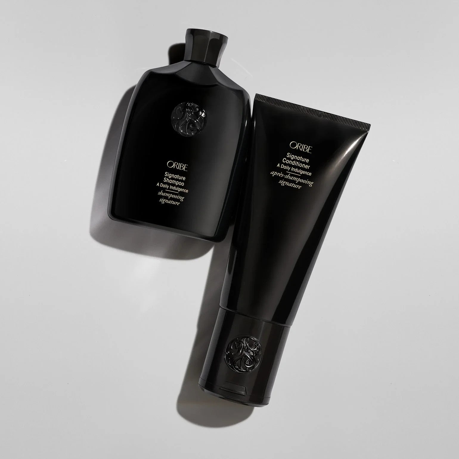 Shop Rescue Spa Oribe Signature Shampoo and Conditioner set in black bottles for daily hair nourishment.