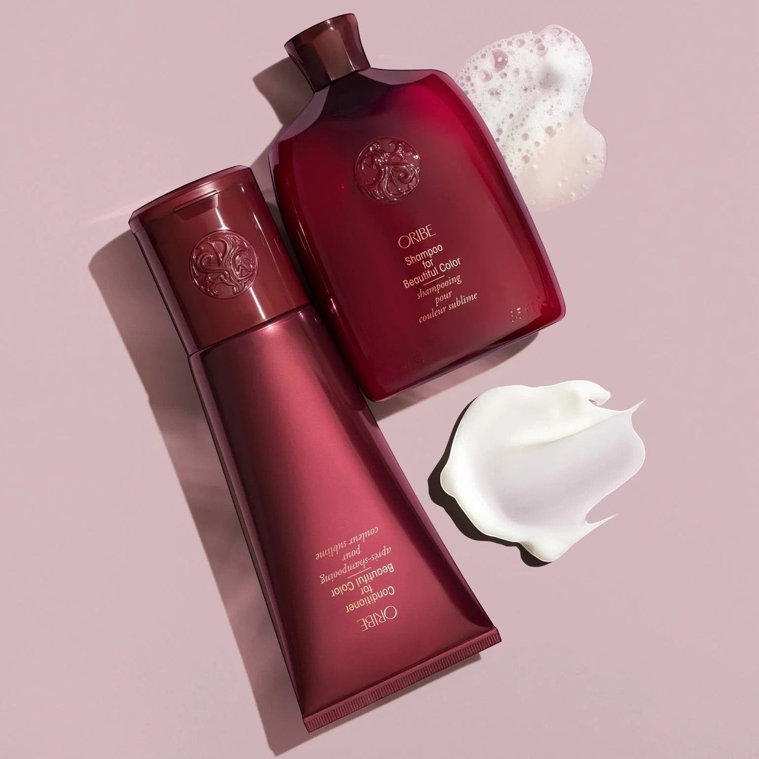Shop Rescue Spa Oribe Shampoo and Conditioner for Beautiful Color set with product texture samples on pink background