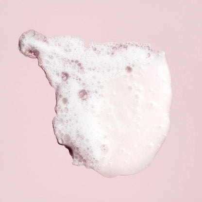 Shop Rescue Spa Oribe Shampoo for Beautiful Color lather texture on a soft pink background