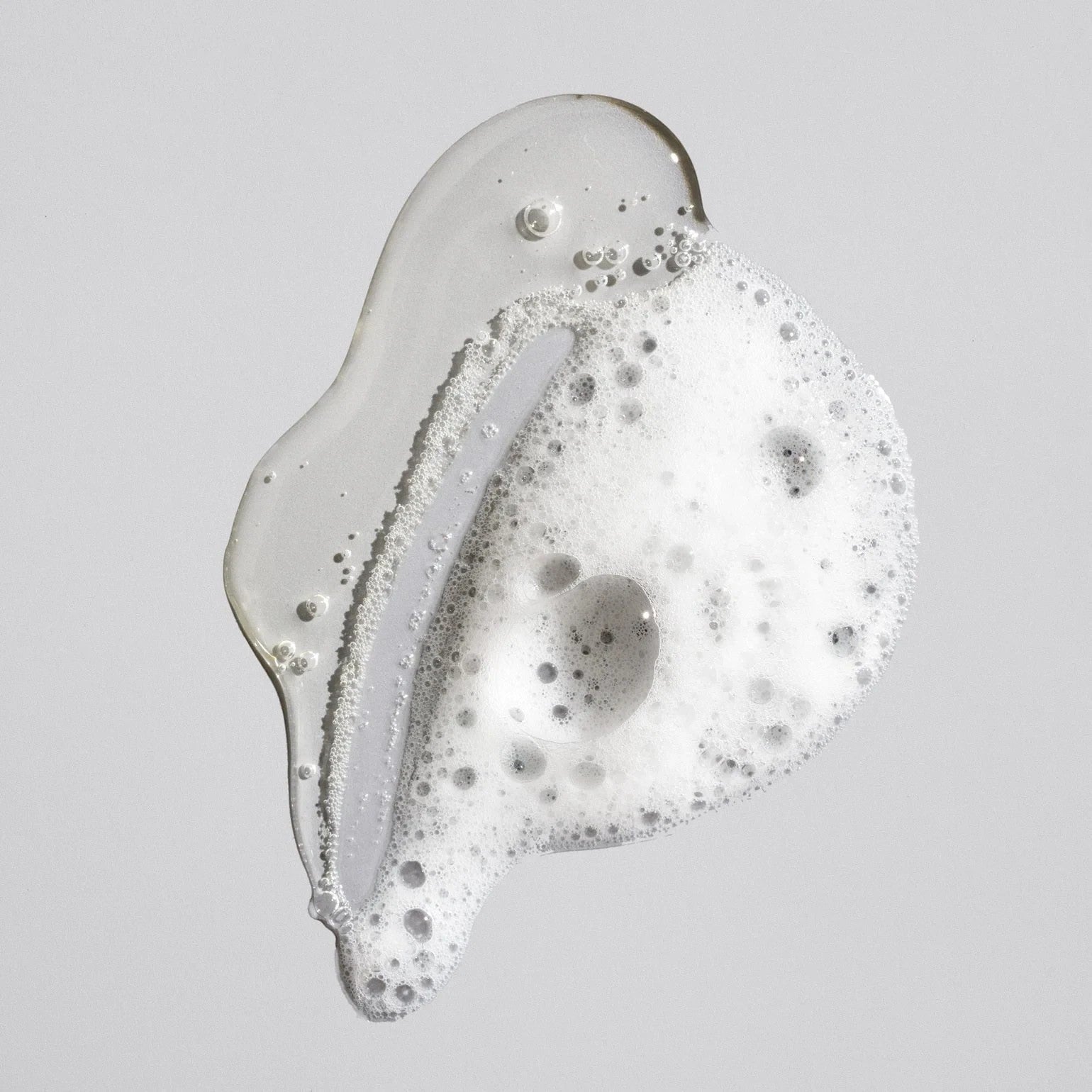 Shop Rescue Spa Oribe Signature Shampoo clear gel texture with white lather bubbles on a neutral background