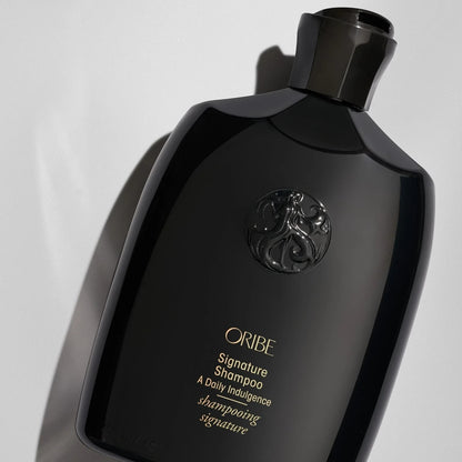 Shop Rescue Spa Oribe Signature Shampoo in a sleek black bottle with gold lettering and embossed logo detail.
