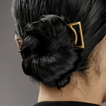 Shop Rescue Spa Oribe Superfine Hair Spray used on a sleek, shiny black hair bun secured with a gold geometric clip.