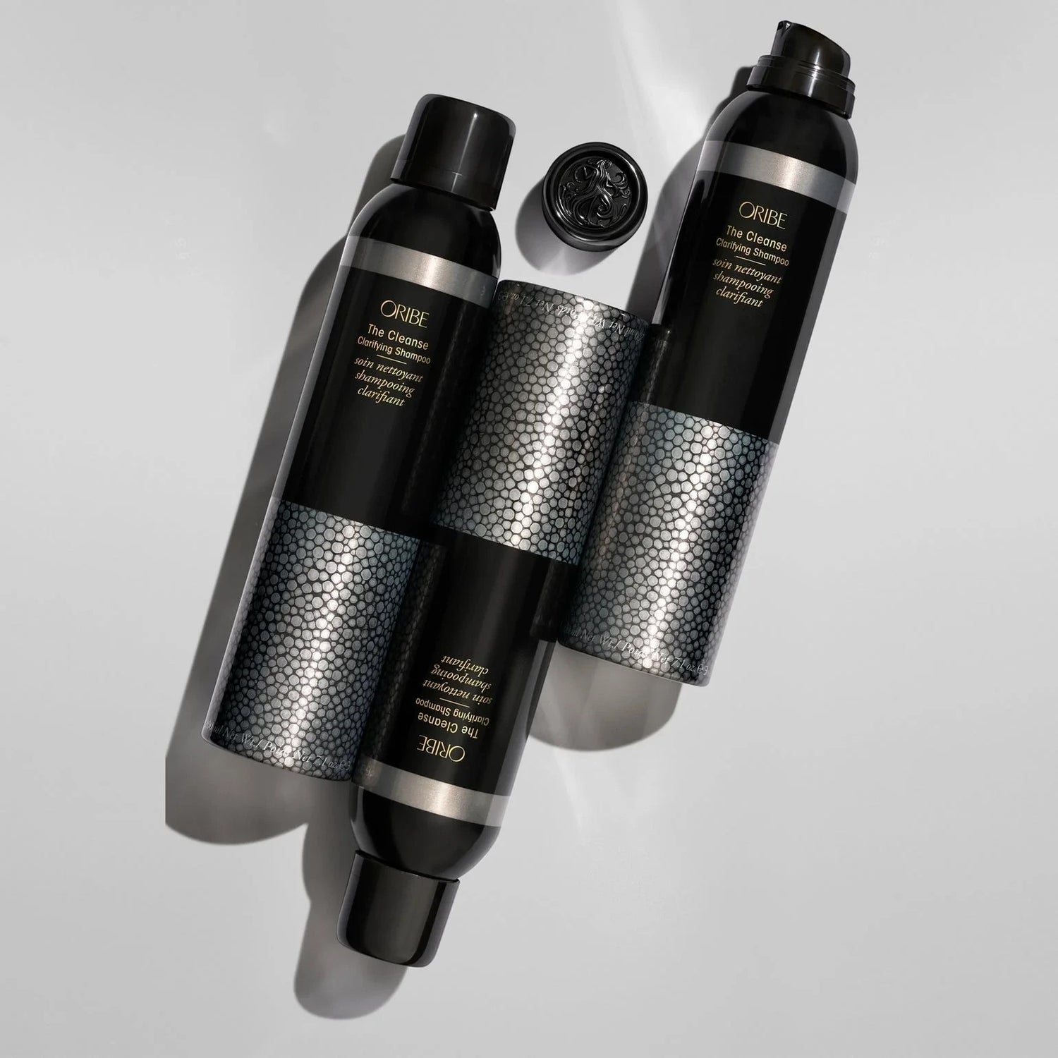 Shop Rescue Spa Oribe The Cleanse Clarifying Shampoo bottles with textured silver bands and black caps.