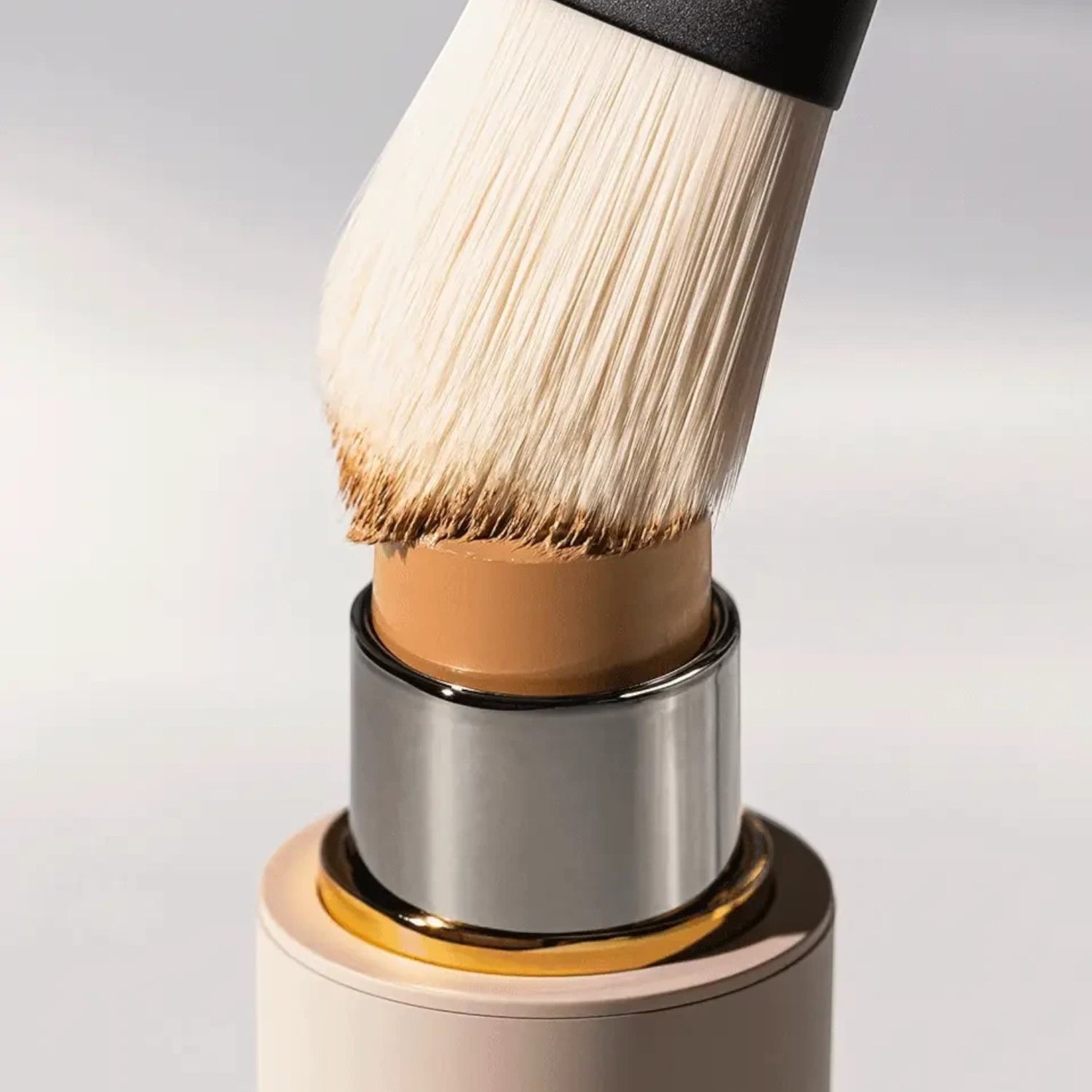 Shop Rescue Spa paddle foundation brush with soft white nylon bristles picking up beige foundation stick product