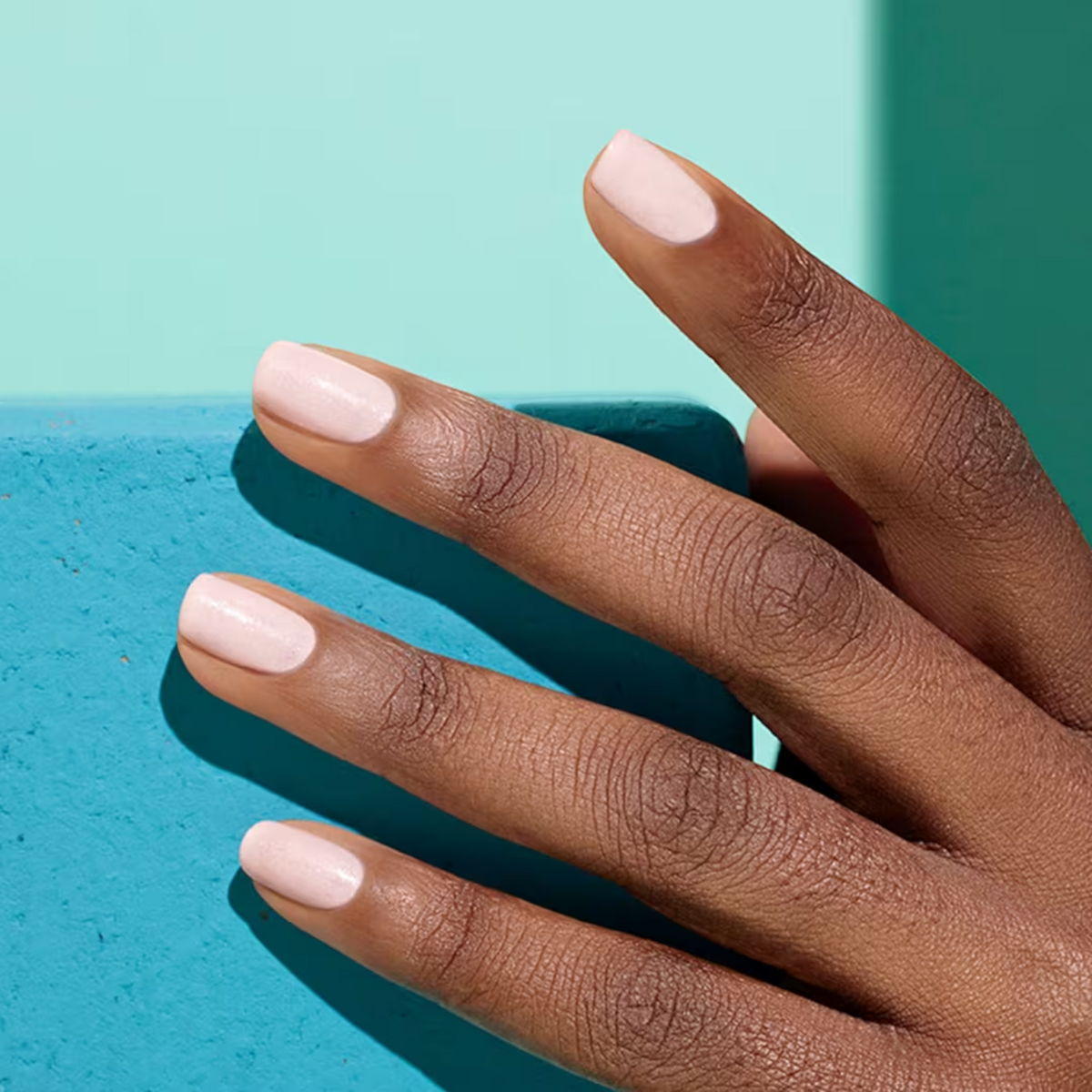 Shop Rescue Spa plant-based nail polish in a soft pastel pink shade on a model&