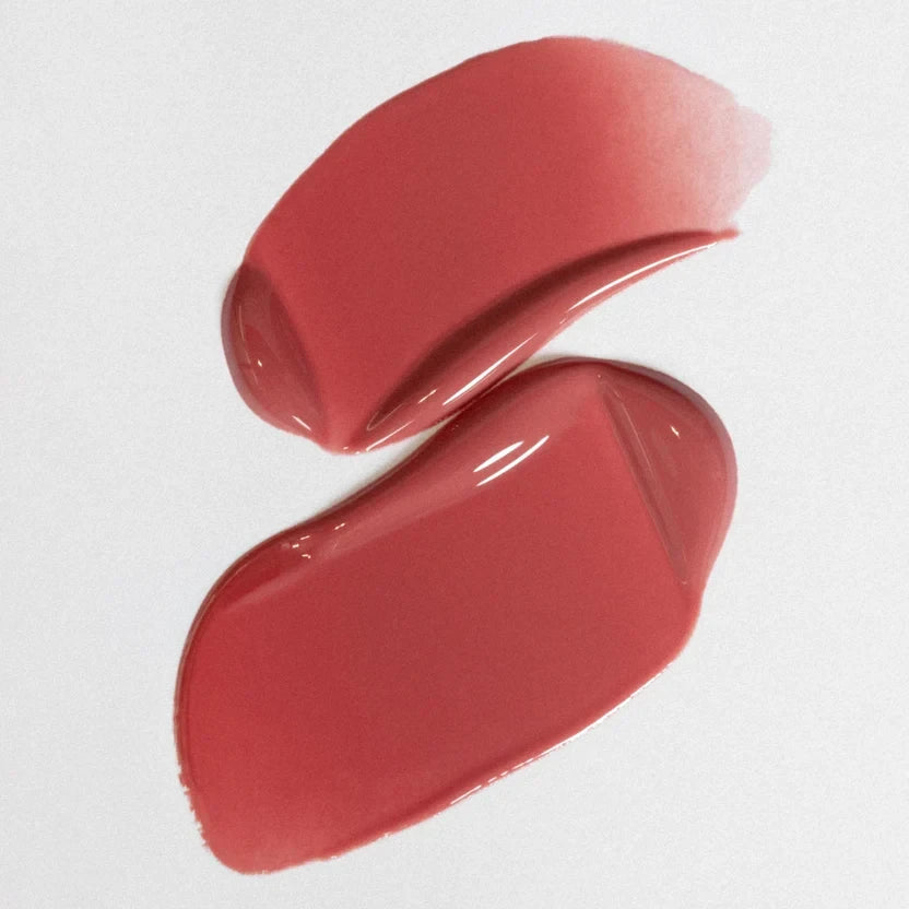 Shop Rescue Spa ÂN-GLOSS Ceramide Lip Tint in a shimmery pink shade showing a smooth, glossy texture swatch