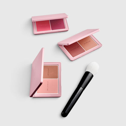 Shop Rescue Spa Powder II brush with white bristles and black handle next to three Westman Atelier blush palettes
