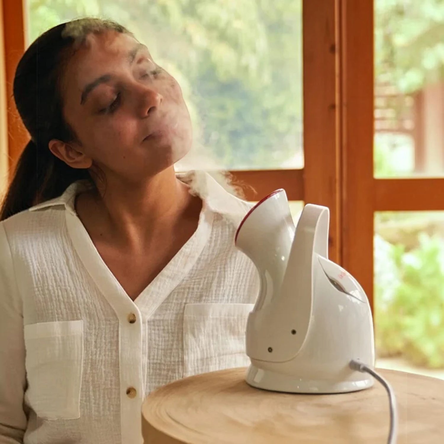 Shop Rescue Spa Pro Facial Steamer in white, providing a relaxing steam treatment to a woman for hydrated skin.