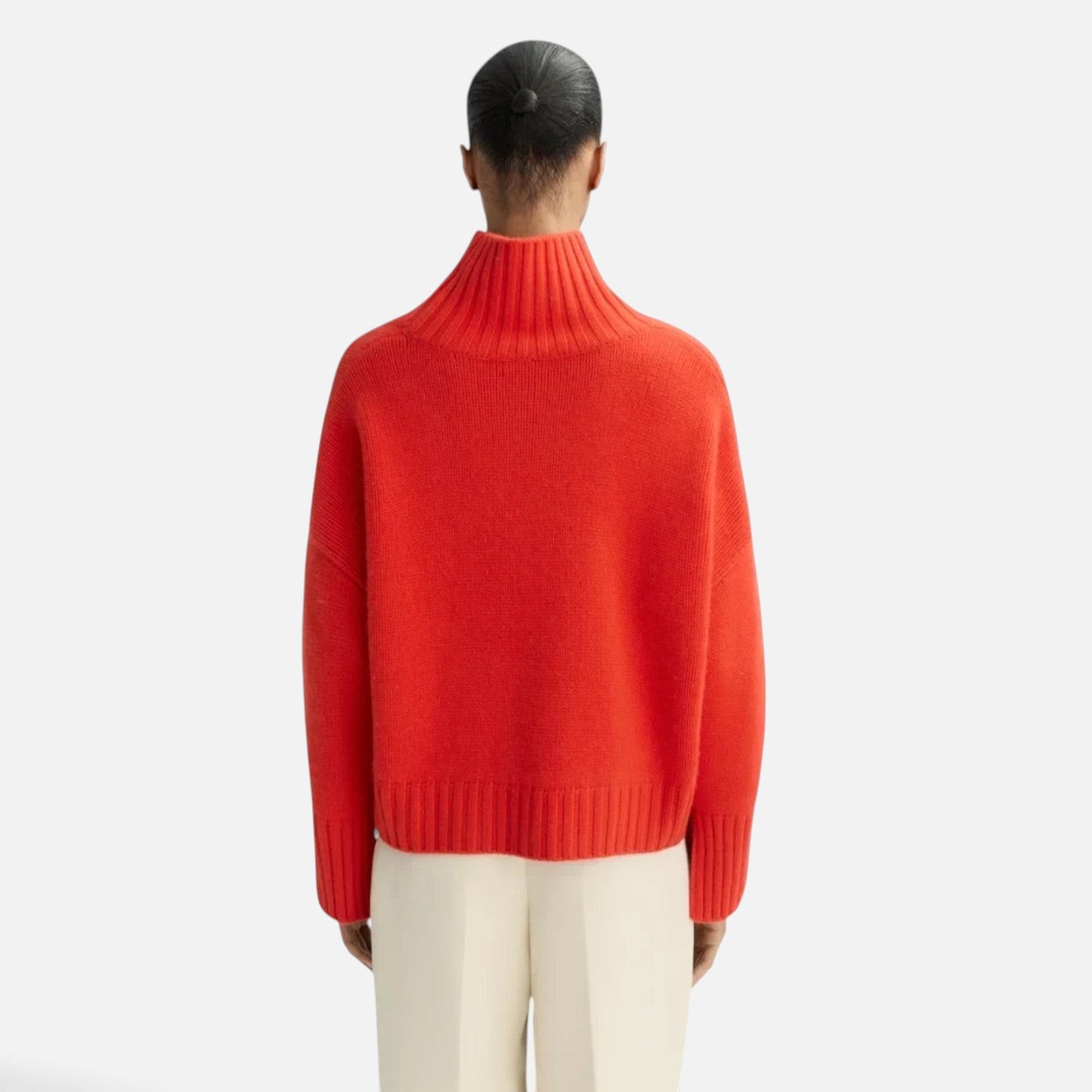 Back view of a model wearing a Shop Rescue Spa chunky red cashmere turtleneck sweater with ribbed details.