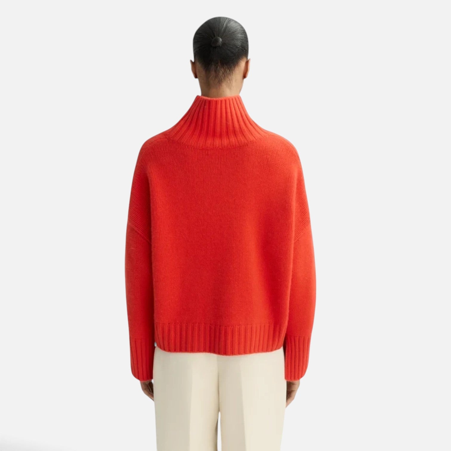 Back view of a model wearing a Shop Rescue Spa chunky red cashmere turtleneck sweater with ribbed details.