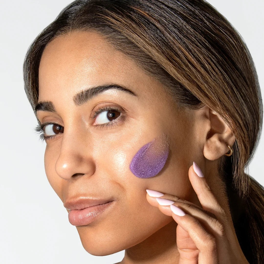Shop Rescue Spa ReSURFACE Skin Polish applied as a purple exfoliating cream on a woman&