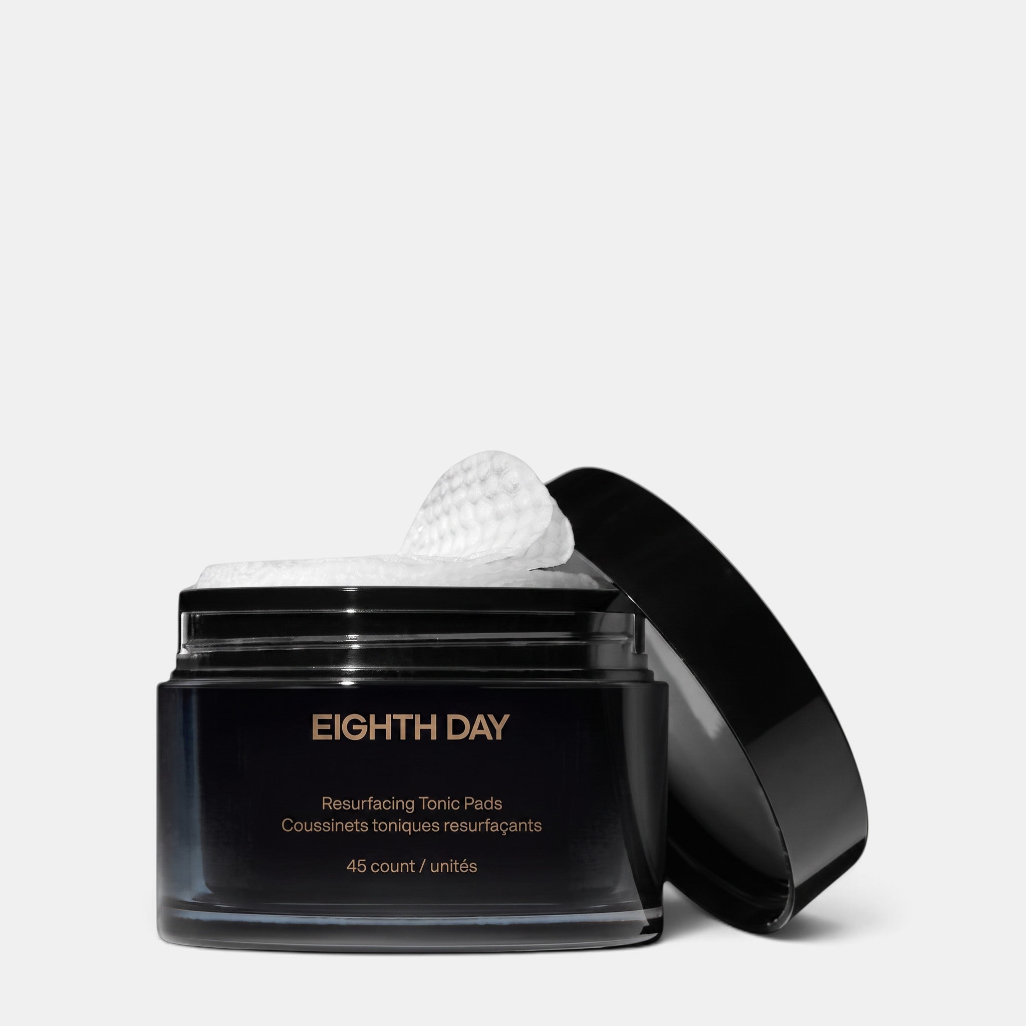 Shop Rescue Spa Eighth Day Resurfacing Tonic Pads in a black jar with one textured exfoliating pad on top
