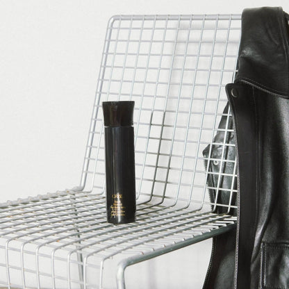 Shop Rescue Spa Royal Blowout heat styling spray bottle on a modern wire chair with a black leather jacket.