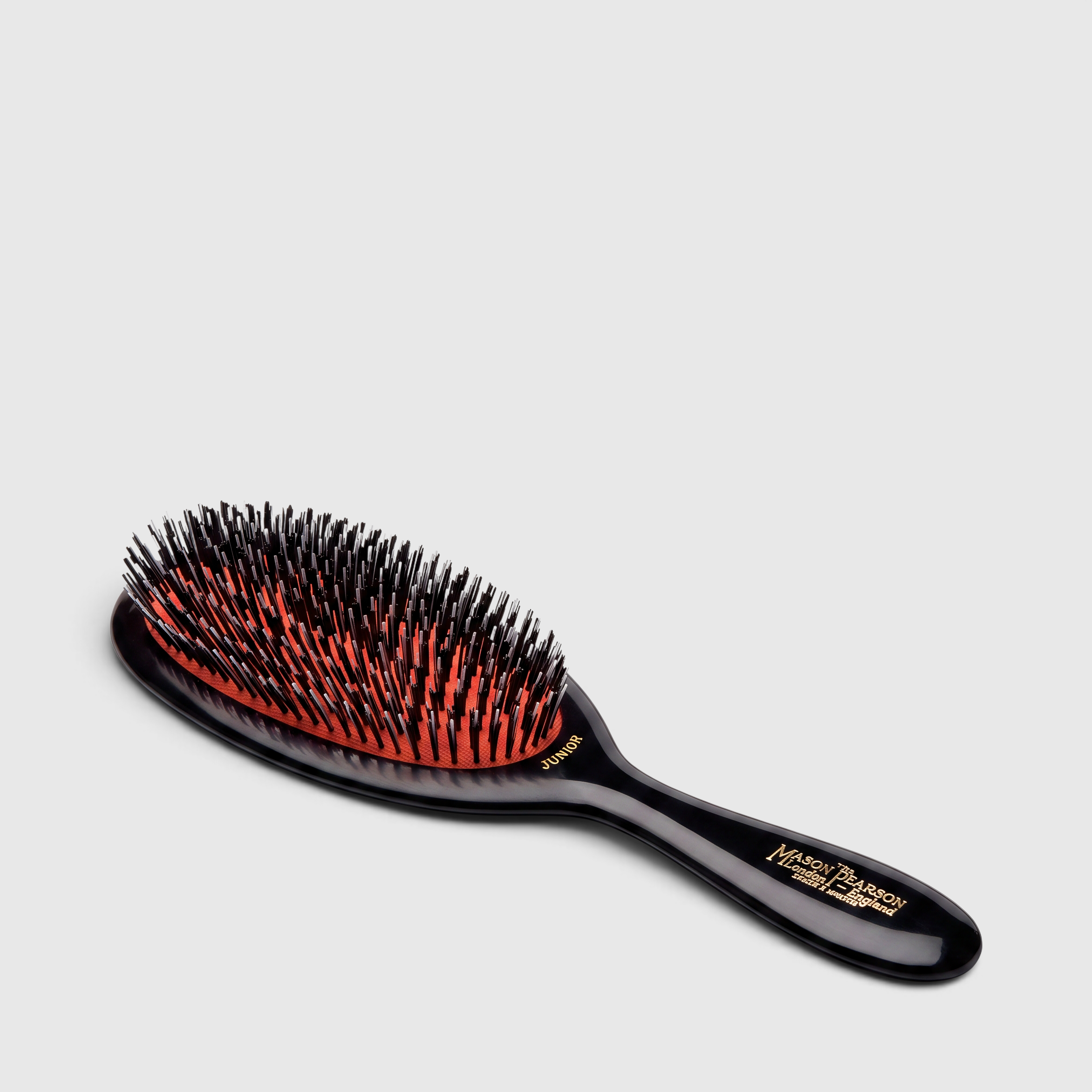 Shop Rescue Spa Mason Pearson Junior Mixture hair brush in ruby with nylon and boar bristles on a pneumatic cushion.
