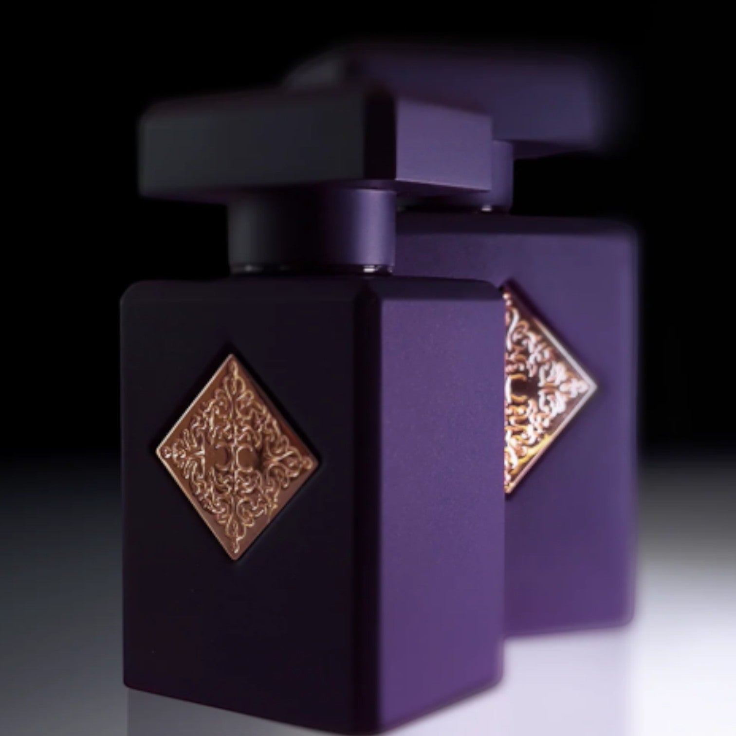 Shop Rescue Spa Side Effect Eau De Parfum bottle in matte purple with gold emblem. Notes of cinnamon, rum, tobacco, vanilla.