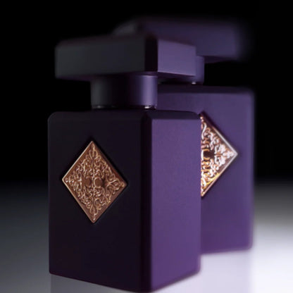 Shop Rescue Spa Side Effect Eau De Parfum bottle in matte purple with gold emblem. Notes of cinnamon, rum, tobacco, vanilla.