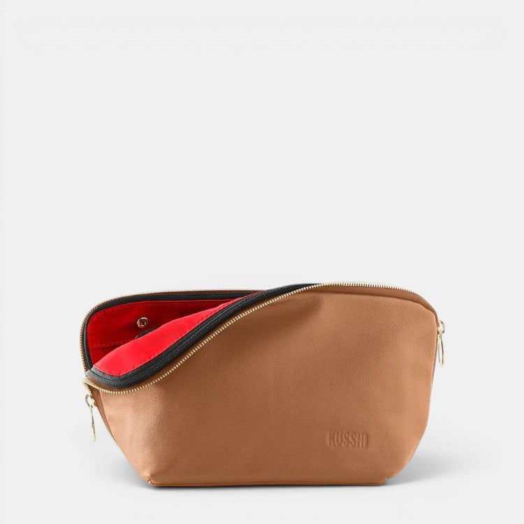 Shop Rescue Spa Signature brown leather makeup bag with red interior and gold zipper. Opens on three sides for easy access.