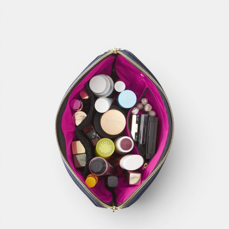 Shop Rescue Spa Signature Makeup Bag in navy blue leather with a bright pink interior, organized with various makeup products.