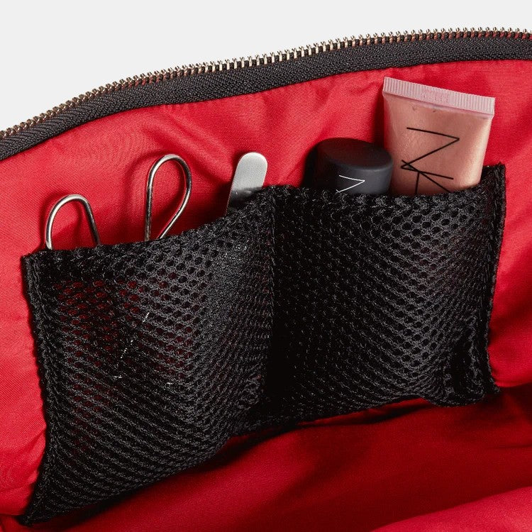Shop Rescue Spa Signature Leather Makeup Bag with red interior and black mesh pockets holding makeup.