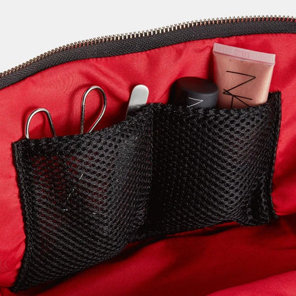 Shop Rescue Spa Signature Leather Makeup Bag with red interior and black mesh pockets holding makeup.
