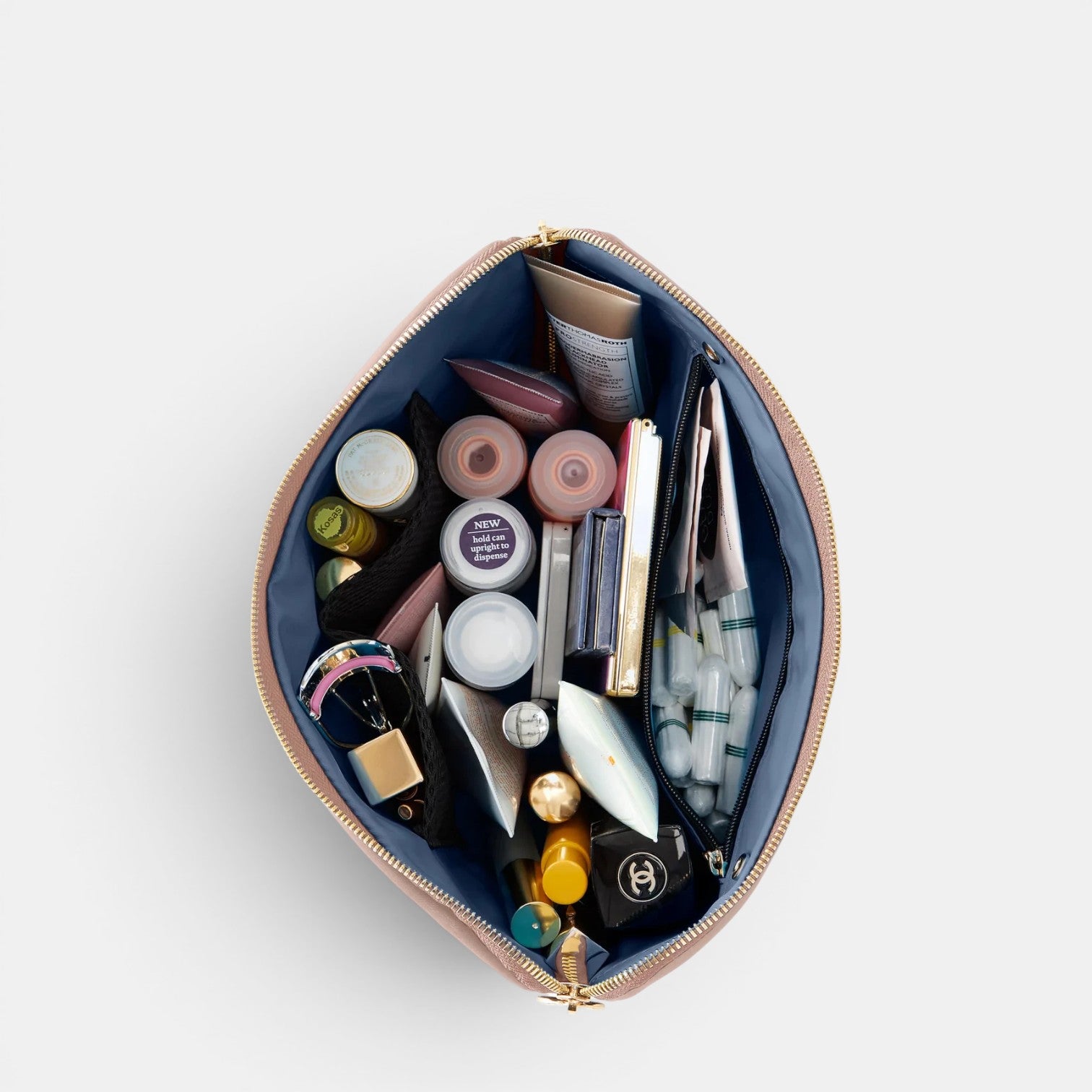 Shop Rescue Spa Signature Leather Makeup Bag, rose gold, open with multiple compartments filled with beauty products and toiletries.