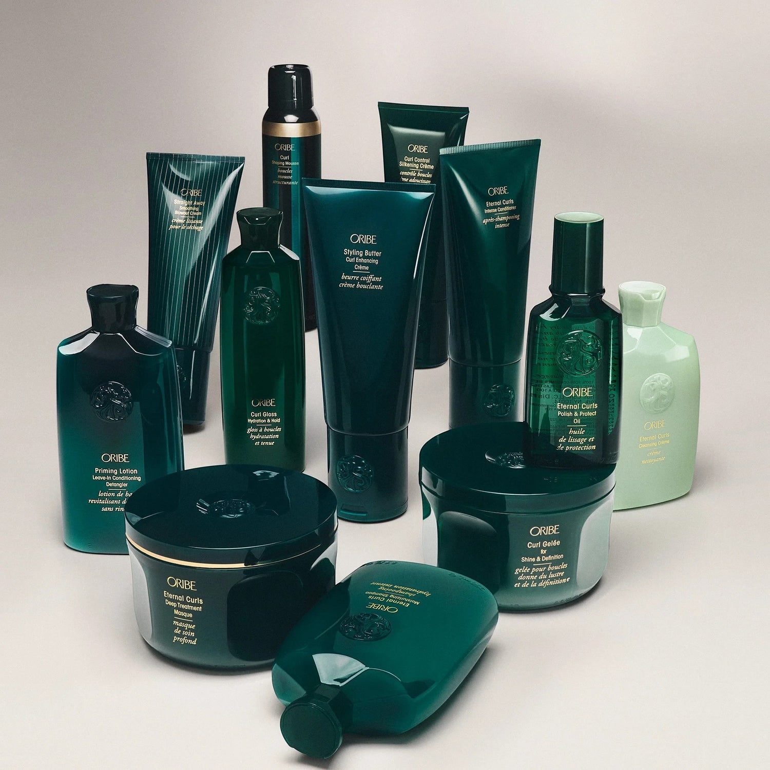 Shop Rescue Spa ORIBE Styling Butter Curl Enhancing Cream in a dark teal tube, defining coily curls with shea butter and avocado oil.