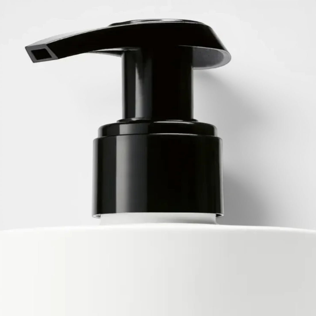 Shop Rescue Spa Suede Hand Lotion with black pump dispenser on white bottle. Woody, aromatic scent.