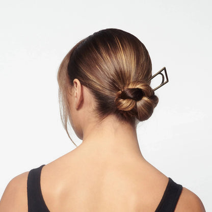 Shop Rescue Spa Superfine Hair Spray used to style a sleek, shiny bun with a geometric hair pin on highlighted hair