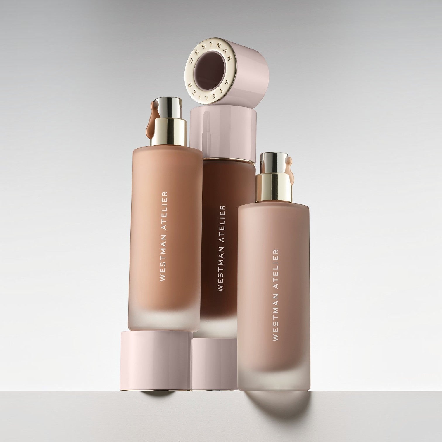 Shop Rescue Spa Supreme Bio-Complex Foundation bottles in various shades with gold pumps and pale pink caps.