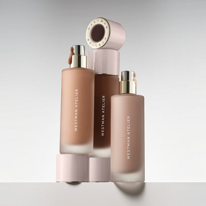 Shop Rescue Spa Supreme Bio-Complex Foundation bottles in various shades with gold pumps and pale pink caps.