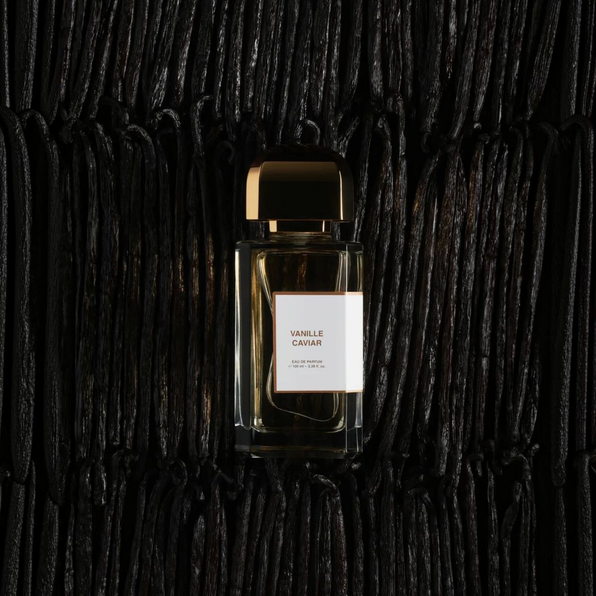 Shop Rescue Spa Vanille Caviar eau de parfum bottle resting on a bed of dark, textured vanilla beans.