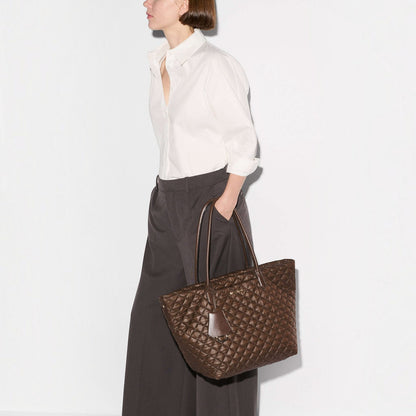 Shop Rescue Spa walnut quilted nylon medium daily tote bag with Italian leather handles carried by a woman