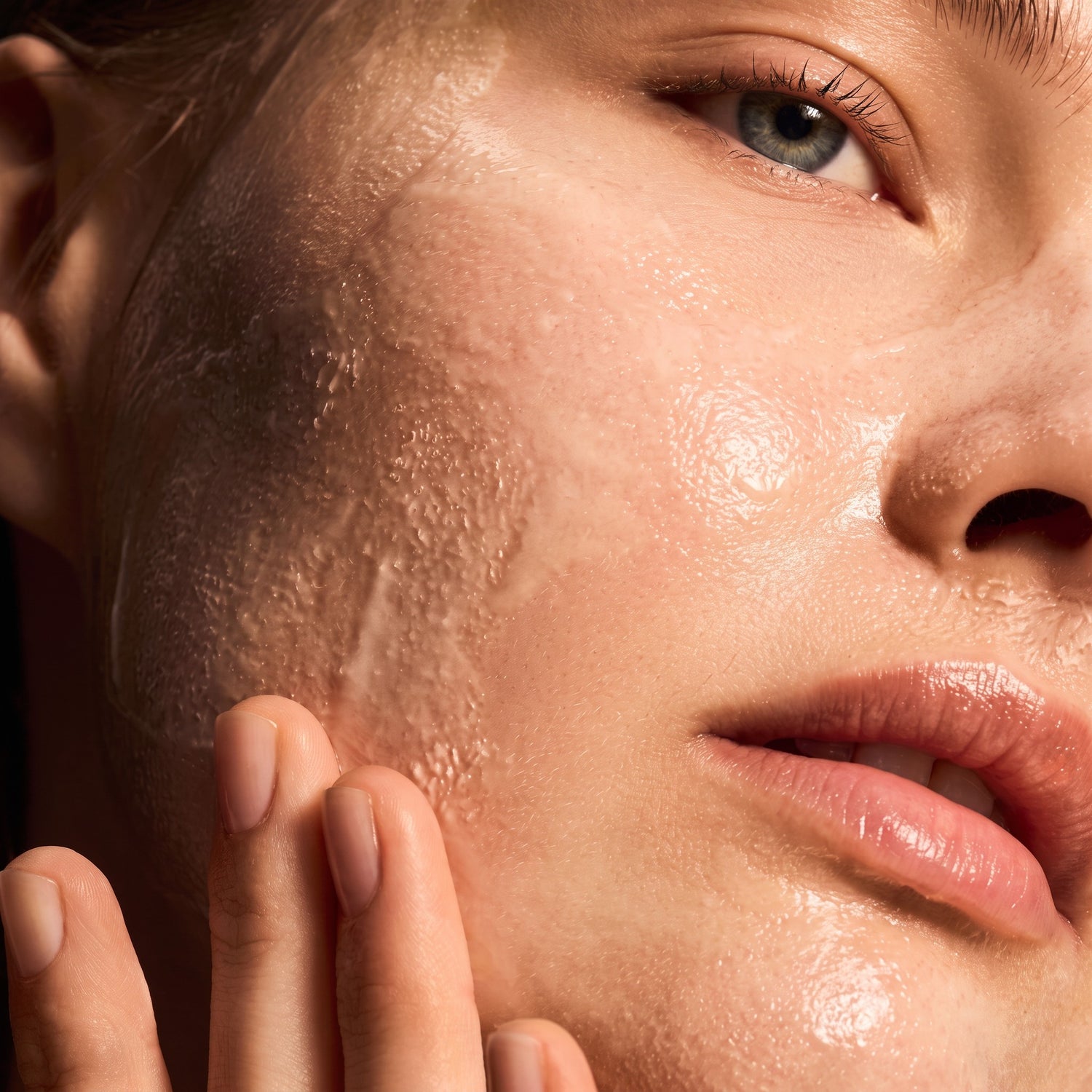 Shop Rescue Spa Warming Honey Cleanser applied as a rich, golden gel texture on a woman&