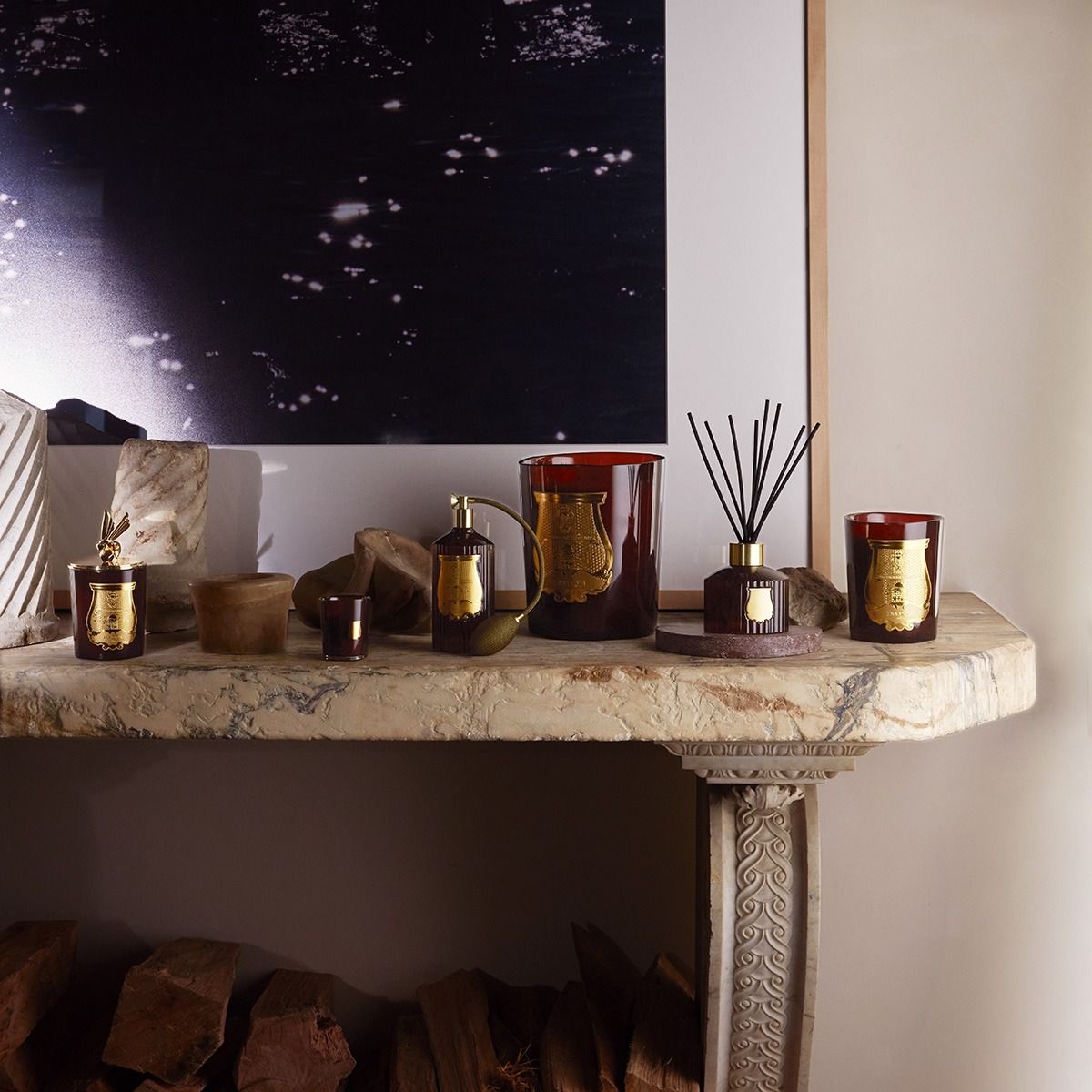 Decorative items on a stone mantelpiece with a starry night painting in the background.