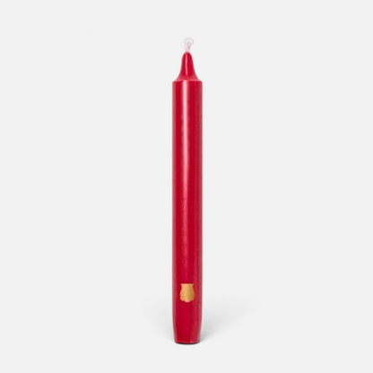 Shop Rescue Spa Madeleine taper candle in red wax with a small gold emblem detail on a plain background