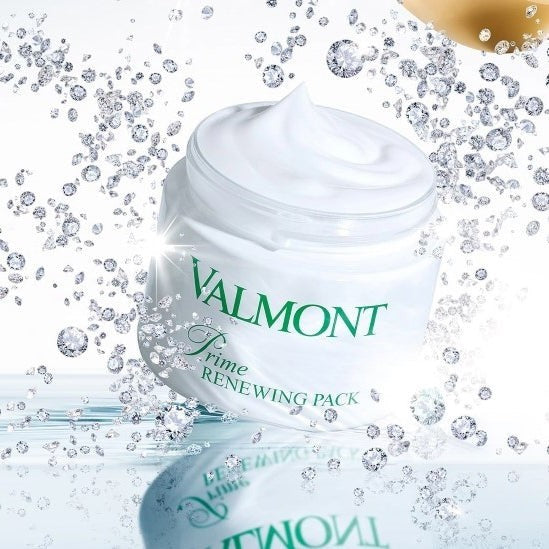 Open Valmont Prime Renewing Pack jar with visible cream inside, surrounded by small diamonds on a styled surface.