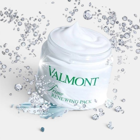 Open Valmont Prime Renewing Pack jar with visible cream inside, surrounded by small diamonds on a styled surface.