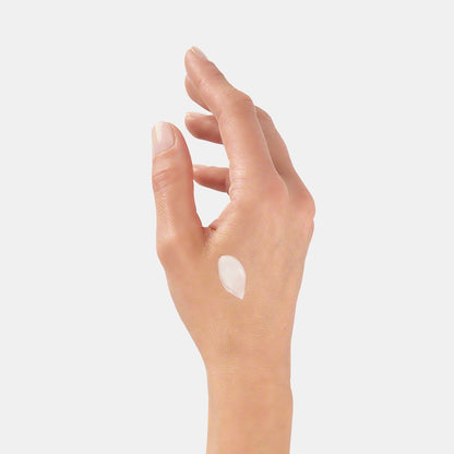 Right hand with Valmont Prime Renewing Pack cream applied near thumb area, showing texture on skin.