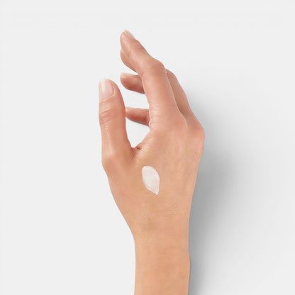 Right hand with Valmont Prime Renewing Pack cream applied near thumb area, showing texture on skin.